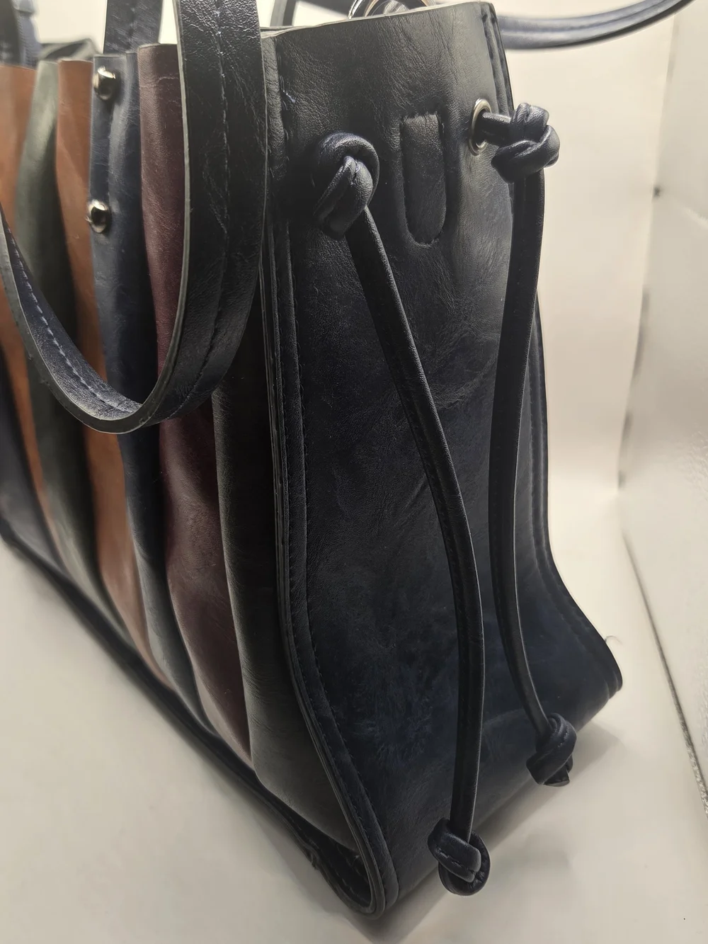 Shopper tote bag made of narrow strips of black, brown, and red leather